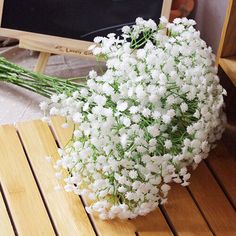 a bouquet of white flowers sitting on top of a wooden table