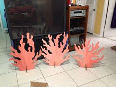 some corals are sitting on the floor in front of a television set and other decorations