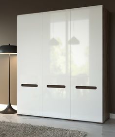 a white cabinet with two doors in a living room next to a lamp and rug