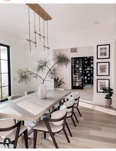 the dining room table is surrounded by white chairs