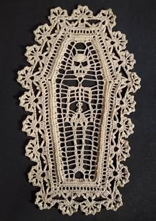 a crocheted doily is shown on a black surface