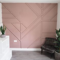 a living room with a chair, plant and wooden paneling on the wall behind it