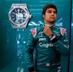 a man standing in front of a wall with a watch on it