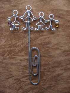 a group of people holding hands on top of a paper clip next to a pin