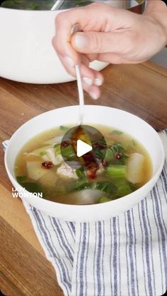 a person is spooning soup into a bowl