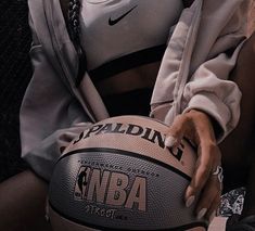 a close up of a person holding a basketball in front of their face with the nike logo on it