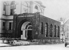 an old black and white photo of a church with a car parked in front of it