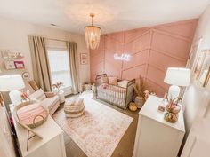 a baby's room with pink walls and furniture in the corner, including a crib