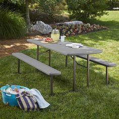 a picnic table with two benches in the grass