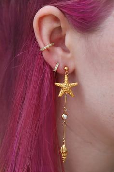 Channel your inner mermaid by rocking my under the sea drops! Featuring handmade starfish, spiral shells and pearls inspired by the ocean floor. The starfish are handmade by an indigenous Thai hill tribe from sterling silver, then plated in 14k gold in Rhode Island. They are very lightweight but perfect for a night out dancing as they have immediate movement on their own! These lovely long earrings pop out when you walk and show up even with long hair worn down when other earrings tend to disappear in photos. Manmade pearls Sterling silver starfish & shells handmade and 14k gold plated 14k gold-fill nickel-free posts with strong rubber backs which are more secure than metal backs 3.25" long Bohemian Gold Starfish Jewelry, Ocean-inspired Dangle Pearl Drop Jewelry, Ocean-inspired Pearl Drop Dangle Jewelry, Ocean-inspired Starfish Dangle Jewelry, Gold Starfish Charm Drop Earrings, Gold Starfish Jewelry With Pearl Charm, Shells And Pearls, Spiral Shell, Ocean Floor