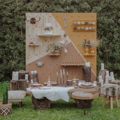 an outdoor table set up for a party with wooden tables and stools in front of it