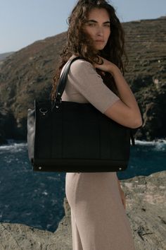 Our black pebbled leather handbag offers a sophisticated solution for those seeking a timeless, adaptable piece that’s spacious enough to carry essentials, yet polished enough for any occasion.   #pebbledleathershoulderbag #pebbledleatherhandbag #pebbledleatherhandbags #pebbledleatherbag #blackpebbledleathercrossbodybag #pebbledleathercrossbody #pebbledleatherconvertiblecrossbodybag Work Handbag, Black Leather Handbag, Large Handbag, Laptop Bag For Women, Travel Essentials For Women, Travel Bags For Women, Black Pebbles, Large Handbags, Black Leather Handbags