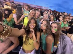 a group of young women standing next to each other in front of a large crowd