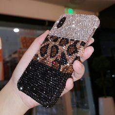 a person holding up a cell phone case with leopard print and sequins on it