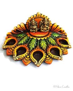 an orange and green brooch with two birds on it