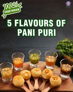 five flavors of pani puri on a wooden platter with four shot glasses