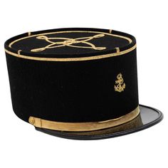 A rare French Military Academy Officer's hat or cap from the 1970s. These special and unique hats are part of the uniform of students studying to become officers in the French Military. This cap features a black leather brim on black felt with a gold braid around the top, a gold braid cross on the top, a gold band across the brim with gold studs, and a gold emblem on the front. 6.25"w x 10"d x 4.25"h. Wear consistent with age and use. French Hats, Hat French, French Military, Black Tears, Military Academy, Unique Hats, Vintage Military, Black Felt, Gold Studs