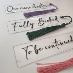 three name tags with tassels attached to them