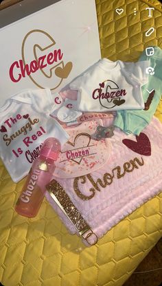 baby clothes and personal items are displayed on a yellow quilted bed sheet with the name chozen written on it