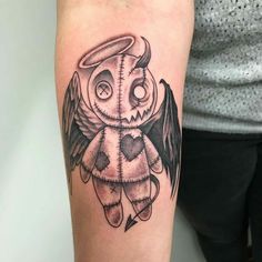 a black and white owl tattoo on the right arm, with an angel above it