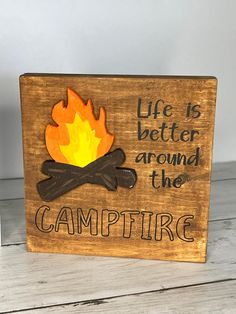 a wooden sign that says life is better around the campfire