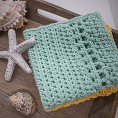 there is a crocheted blanket and starfish on the table