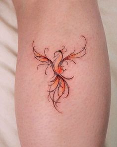 a woman's thigh with a tattoo design on her leg and an orange bird