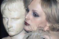 a close up of a mannequin head with feathers