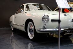 an old white car is on display in a museum