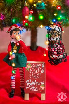 an elf is standing next to a sign with christmas lights on it that says free printable girl elves rules sign