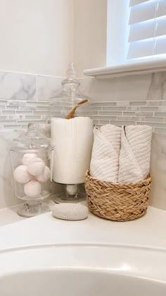 a bathroom sink with towels, soap and other items on top of it in front of a window