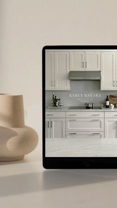 a tablet computer sitting on top of a table next to a white vase and bowl