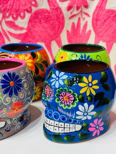 three colorful sugar skulls with flowers painted on them