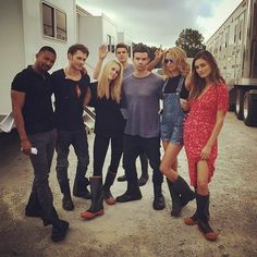 a group of young people standing next to each other in front of a white trailer