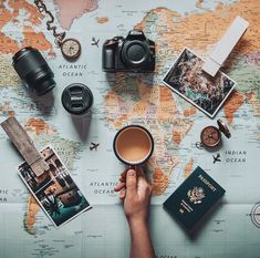 a person holding a coffee cup on top of a map