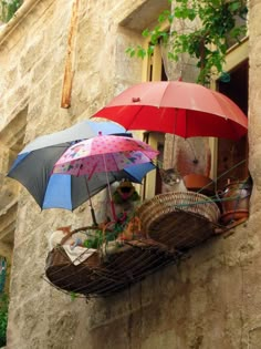 two umbrellas that are sitting on a ledge in front of a building with words written below them