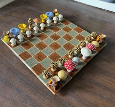 a wooden chess board with many different colored pieces on it, including mushrooms and toades