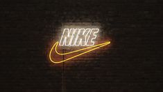 a neon nike sign on a brick wall