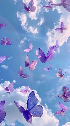 many purple butterflies flying in the sky with white clouds behind them and blue skies above