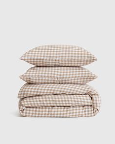 three pillows stacked on top of each other in brown and white gingham checks