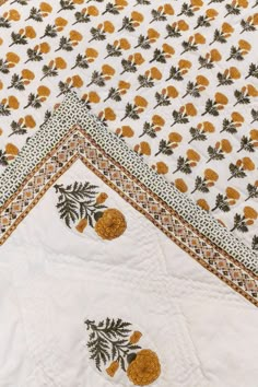 three pieces of white and gold quilting with pineapples on the top one