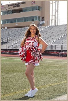 a cheerleader is posing for a photo in front of the bleachers