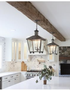 a kitchen with two lights hanging from the ceiling and an island in front of it