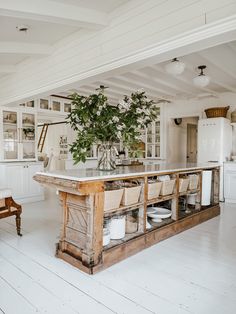 a kitchen with white walls and floors has an island in front of the countertop