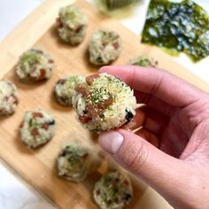 a person holding up a small appetizer in front of some other food items