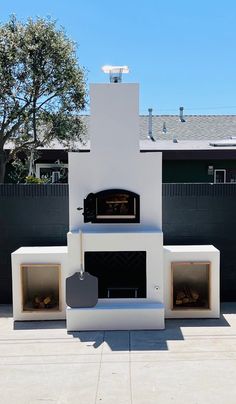 an outdoor pizza oven in the middle of a patio with two open doors on each side