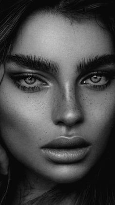 a woman with freckled hair is posing for a black and white photo, her eyes are slightly open