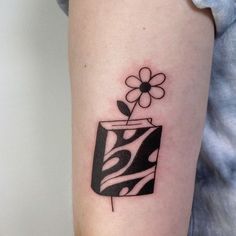 a black and white tattoo on the arm of a woman with a flower in it