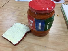 a peanut butter and jelly jar next to a piece of bread