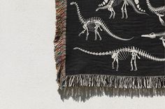 a black and white photo of dinosaurs on a wall hanging from a rope with fringe